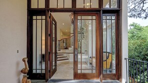 A grand entrance with a wooden door and glass panels, leading to a staircase and a balcony with a railing. - 12 Port Tack -  4 min walk to the ocean.  Views of golf, lagoons & sunset (Hilton Head Island)