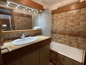 Un bagno con lavandino, specchio e vasca.