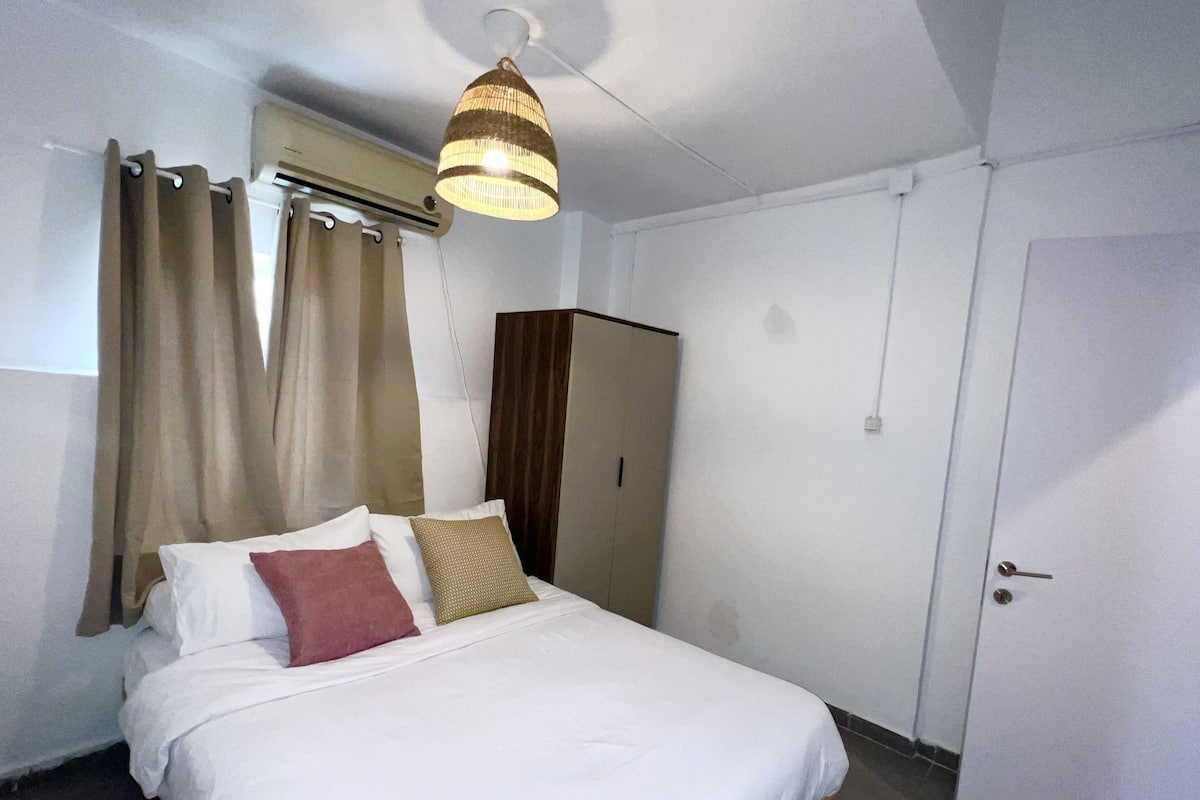 Un dormitorio con cama, armario e iluminación en el techo.
