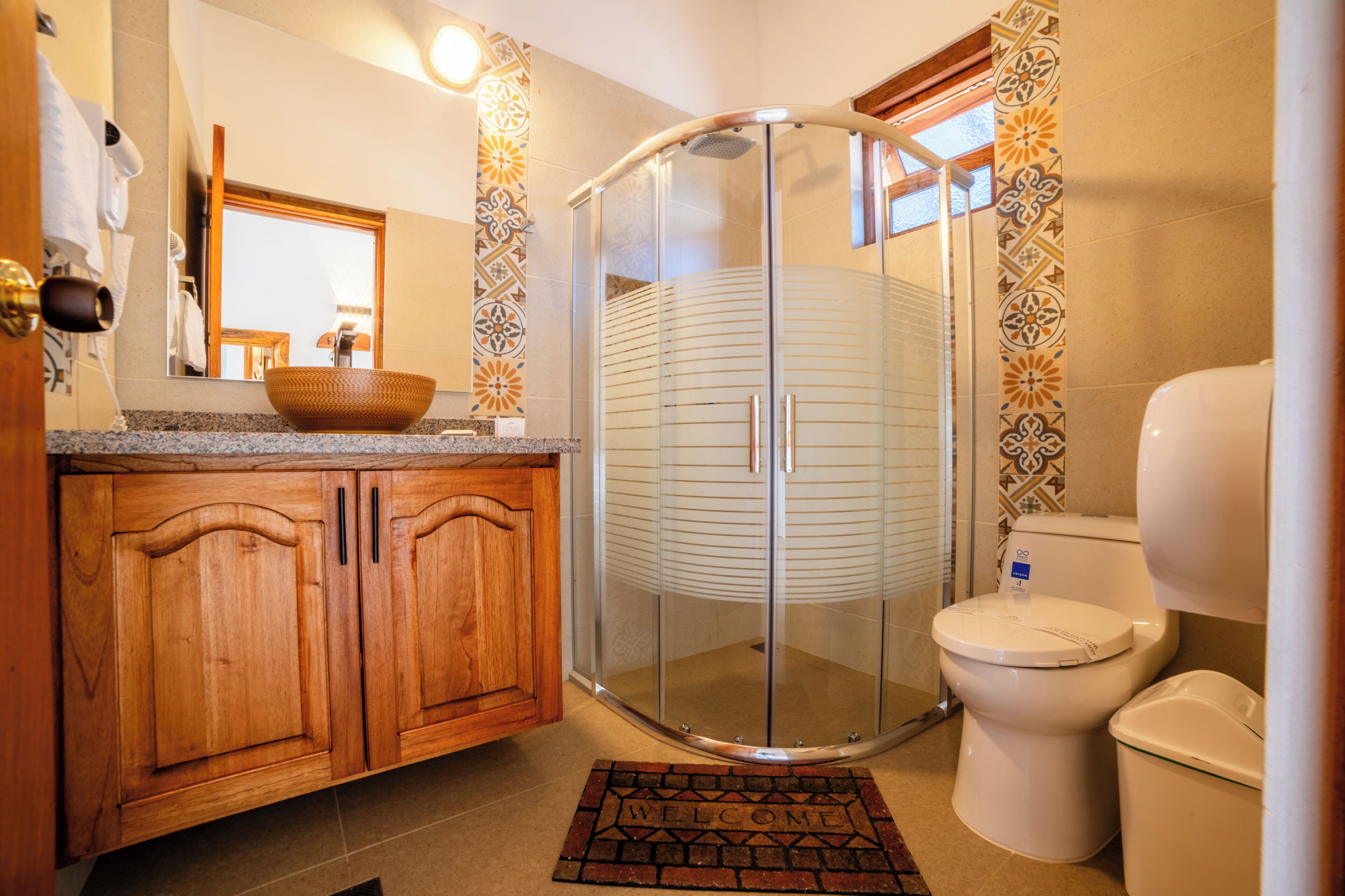 A bathroom with a shower, toilet, and wooden cabinets.