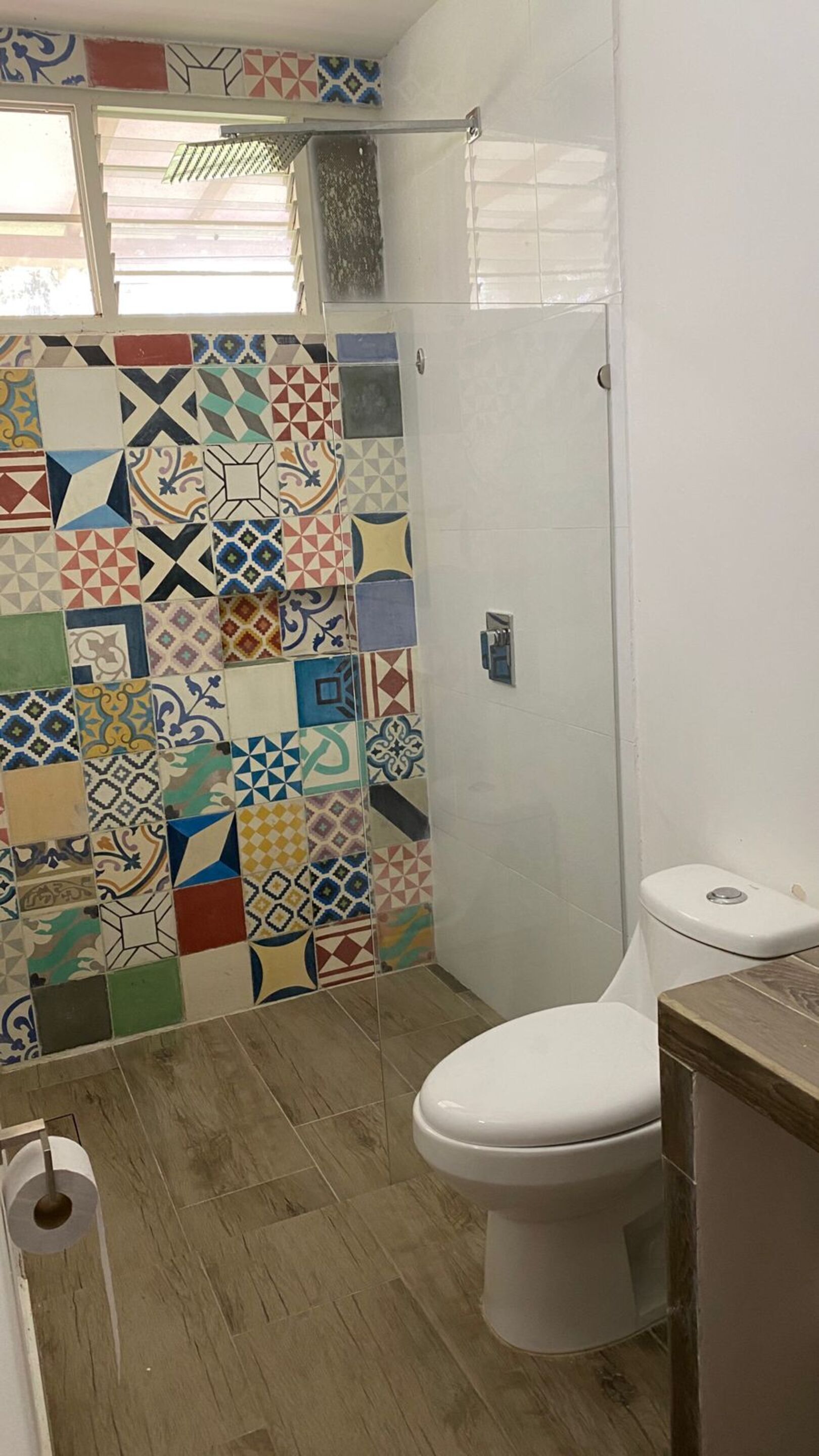 A bathroom with a shower, a toilet, and a sink.