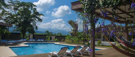 Una piscina al aire libre, tumbonas