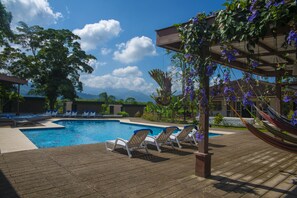 Una piscina al aire libre, tumbonas