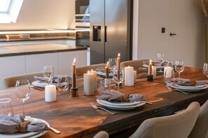 Enjoy a formal dining experience in this well-appointed space with a long table set for a meal.