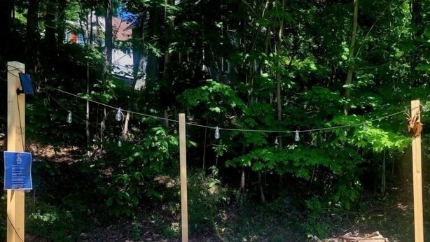 Una boma encenent en un recinte de grava, amb bancs de fusta i un munt de llenya.