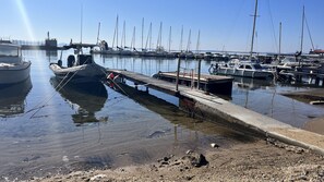 Ein Yachthafen mit vertäuten Booten, einer Betonsteganlage und ruhigem Wasser.