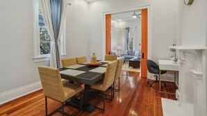 Un espace repas comprenant une table et des chaises, un canapé et un bureau avec une chaise.