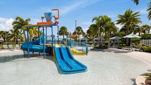 A water park with a blue slide, a water pump, and lounge chairs. - Escape to Our Beautiful and Comfy Home at Solara (Kissimmee)