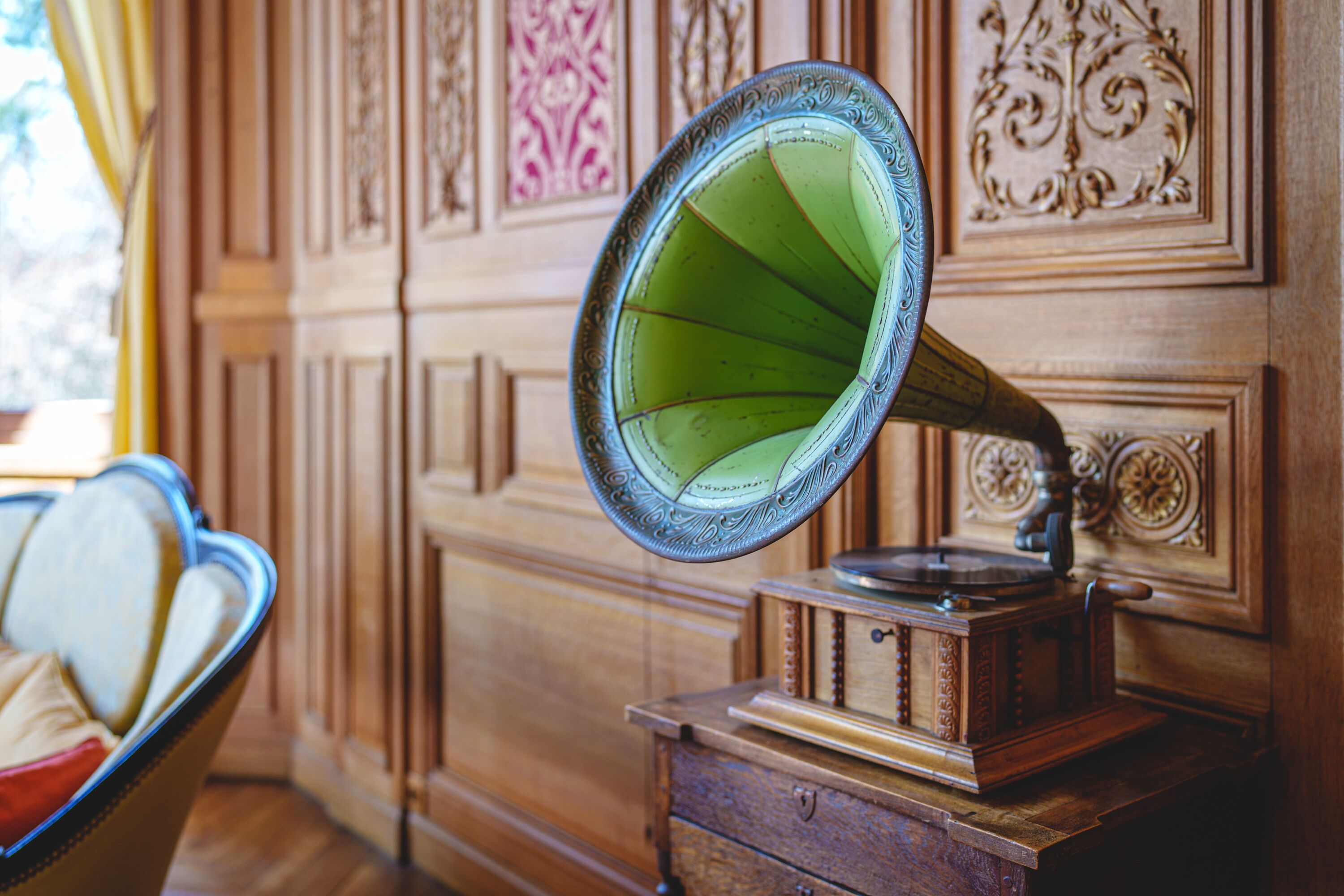 Un tocadiscos antiguo sobre un mueble de madera con paneles decorativos.