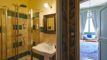 A bathroom with a glass-enclosed shower, a sink, and a mirror.