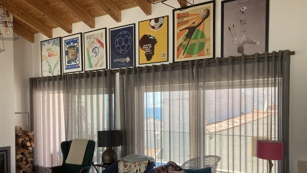 Un salon avec un canapé, des fauteuils, une lampe et une fenêtre avec des rideaux.