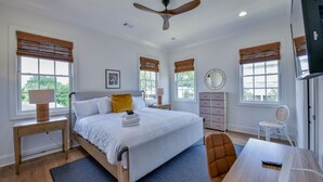 A bedroom with a bed, bedside tables, a desk, a chair, a ceiling fan, and windows with blinds. - Welcome to Tide on 12th! (Tuscaloosa)