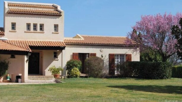 Un bâtiment à deux étages, doté d’un toit plat et d’un petit porche.