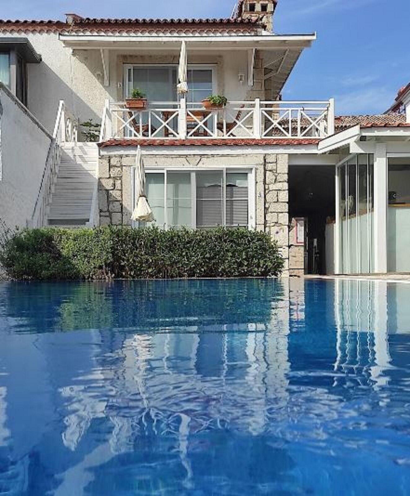 Un edificio de dos pisos con una piscina delantera.