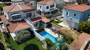 A residential area with multiple houses, a swimming pool, and a well-maintained garden. - Nidus Alaçatı  (Cesme)