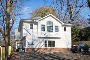 A two-story house with a brick foundation, a central chimney, and a garage.