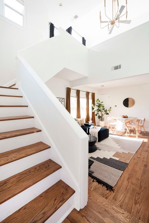 A modern interior with a wooden staircase, a dining area, and a living space.