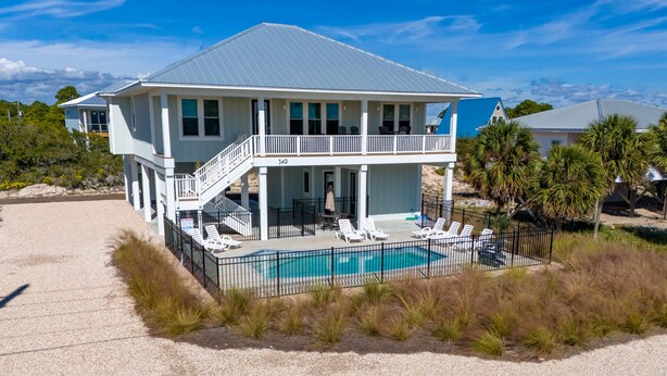 A two-story house with a balcony, a swimming pool, and a beach view. - Gulf Views, 4BR/4BA w/ Game Room, Private Pool w/ Heat, EV Charger (St. George Island)