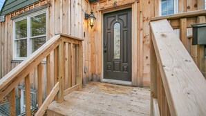 A wooden house with a front door, a staircase, and a window. - A bright & chic 2 bedroom urban apartment (Orangeville)