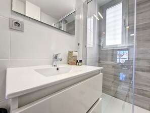 Een douche, een haardroger, handdoeken, toiletpapier