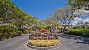 Uma entrada arborizada com uma placa indicando "Waikoloa Beach Villas".