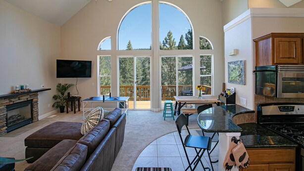 A spacious living area with a fireplace, a large TV, and a cozy seating area. - Donner Lake, Home | Walk to the Lake, Trails, & Family Activities (Truckee)