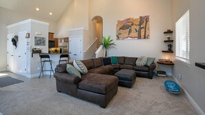 A spacious living room with a sectional sofa, a dining area, and a kitchen. - Donner Lake, Home | Walk to the Lake, Trails, & Family Activities (Truckee)