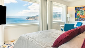 Ein Hotelzimmer mit Bett, Schreibtisch, Stuhl und Fernseher.