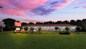 A Red Roof Inn & Suites with a parking lot and a grassy area in front. - Red Roof Inn & Suites Vineland - Buena (Buena)