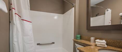 Une salle de bain avec douche, toilettes et lavabo.