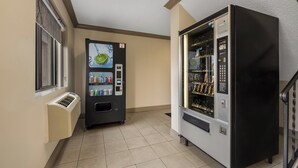 A hallway with a vending machine, a window, and a thermostat. - Red Roof Inn & Suites Vineland - Buena (Buena)