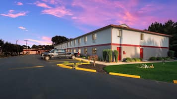 A building with a parking lot and a truck parked in front.