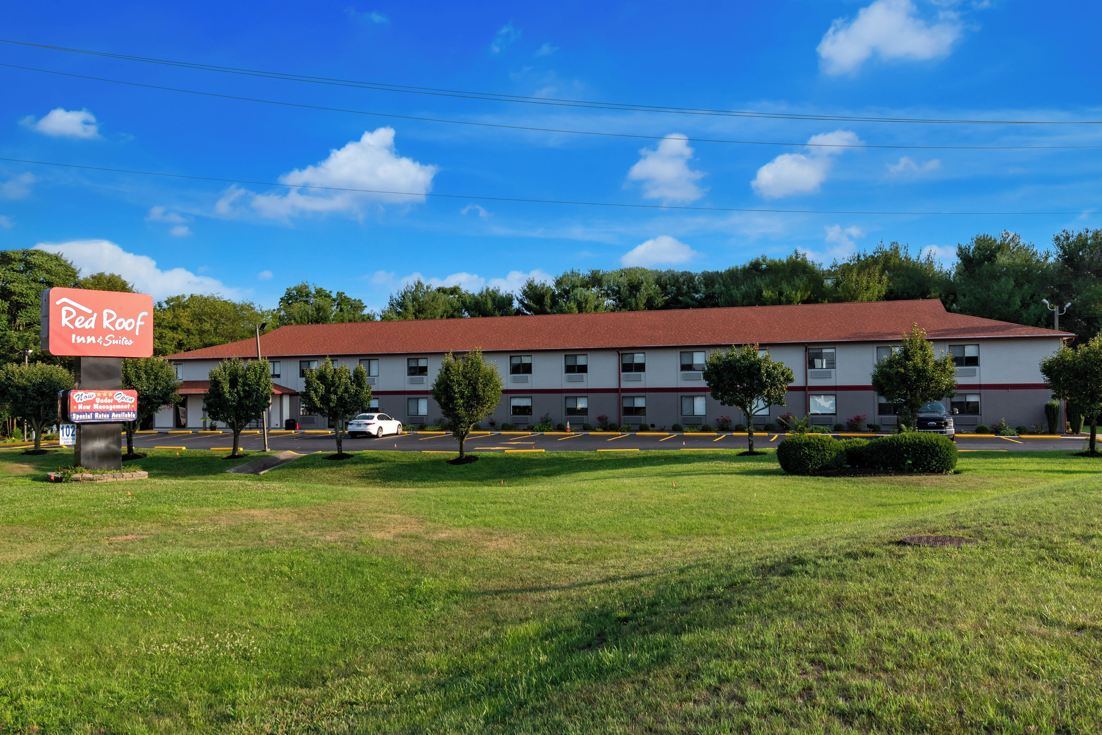 A Red Roof Inn & Suites with a red roof, multiple windows, and a parking lot.