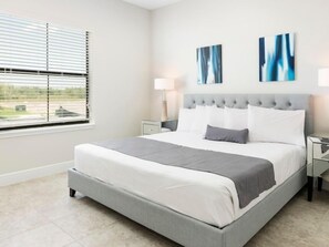 Relax in this serene bedroom with a large bed, tufted headboard, and two bedside tables.