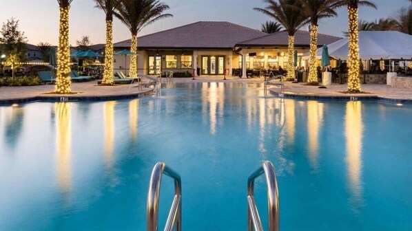 Relax by the pool surrounded by palm trees and lounge chairs.