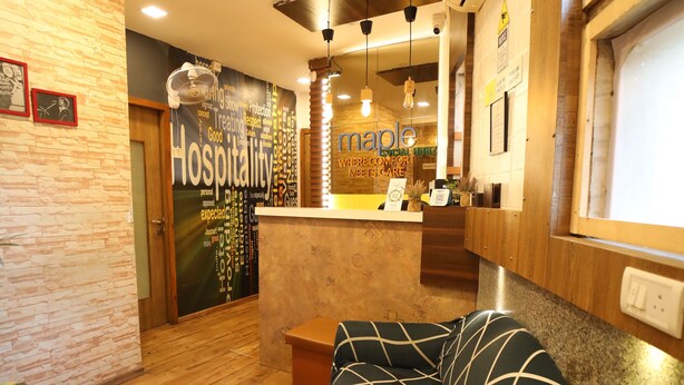 Un vestíbulo de hotel con una recepción, una sala de espera con un sofá, suelo de madera y una pared con una nube de palabras.