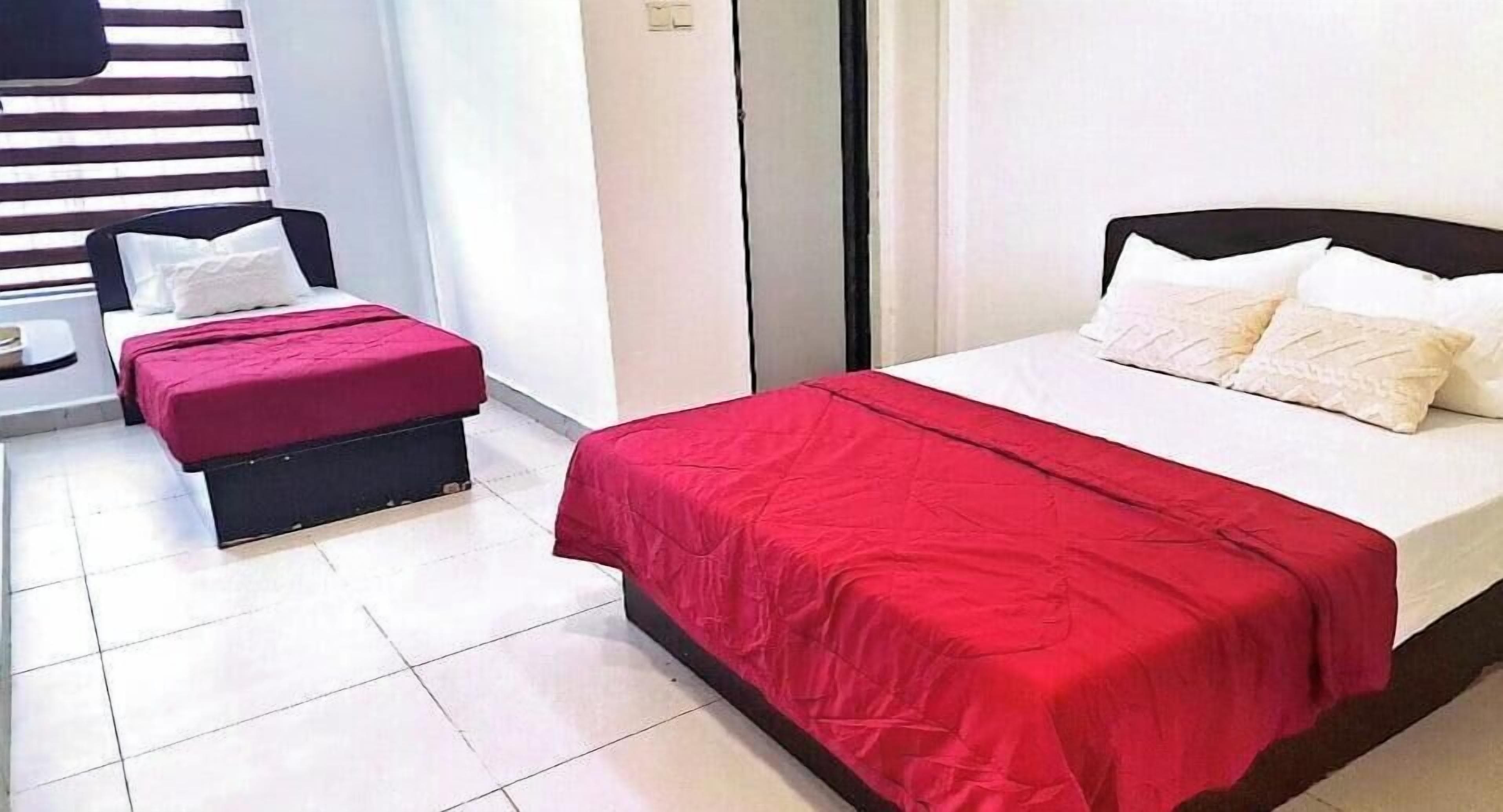 A hotel room with a bed, a small table, and a bench.