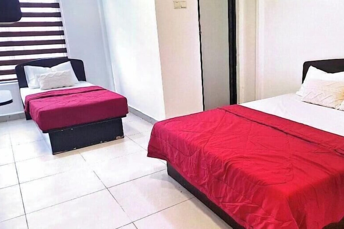 A hotel room with a bed, a small table, and a bench.