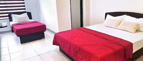 Una habitación de hotel con una cama, una mesita pequeña y un banco.