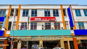 Un edificio de hotel con un llamativo letrero rojo que dice OYO HOTEL LII VIEW.