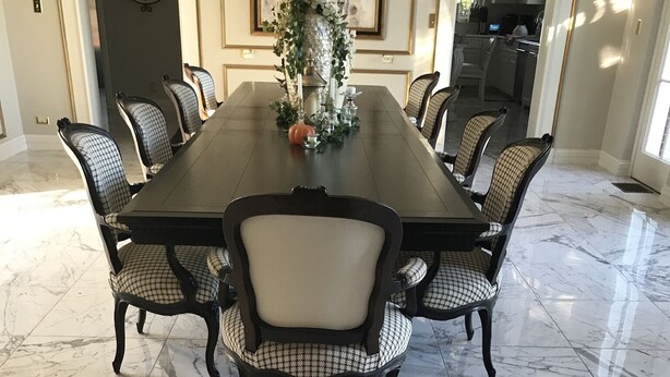 A dining area with a marble floor, a large rectangular table, and six upholstered chairs with a checkered pattern. - 13,000 sq. ft. 6BR Estate on 5 acres Swim Spa, Hot Tub, Pool Table, Game Room (Muncie)