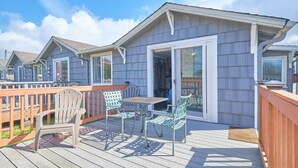 A deck with outdoor furniture and a sliding glass door leading to a covered patio.