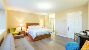 Ein Hotelzimmer mit Bett, einer Couch, einem Schreibtisch und einem Sessel.
