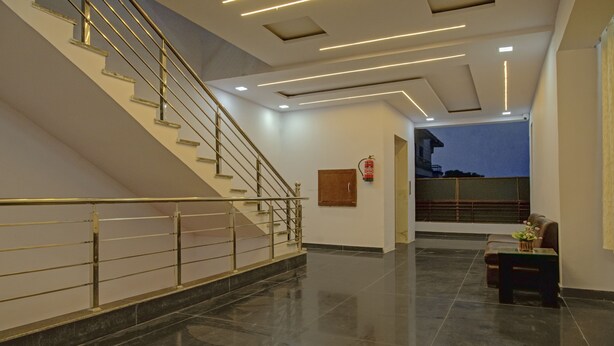 A modern interior with a staircase, polished floors, and a fire extinguisher on the wall. - Treebo The King Mohali (Mohali)