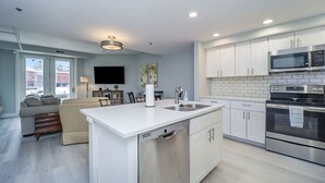 A modern kitchen with white cabinetry, a stainless steel oven, and a built-in microwave. - 2 Bedroom River Front Condo (Manistee)