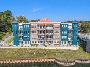 A multi-story building with balconies, a central courtyard, and a waterfront view.
