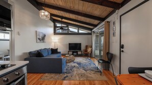 A modern kitchen with a built-in oven and a dining area with a wooden table and chairs. - Newly Updated OCEAN BLOCK 2 bedroom condo, steps away from the beach! (Dewey Beach)