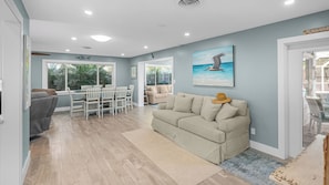 A spacious living area with a dining set, a sofa, and a painting of a pelican on the wall. - 7 minute walk to Siesta Key beach.  Large heated pool/spa. Very private.1/2 acre (Siesta Key)