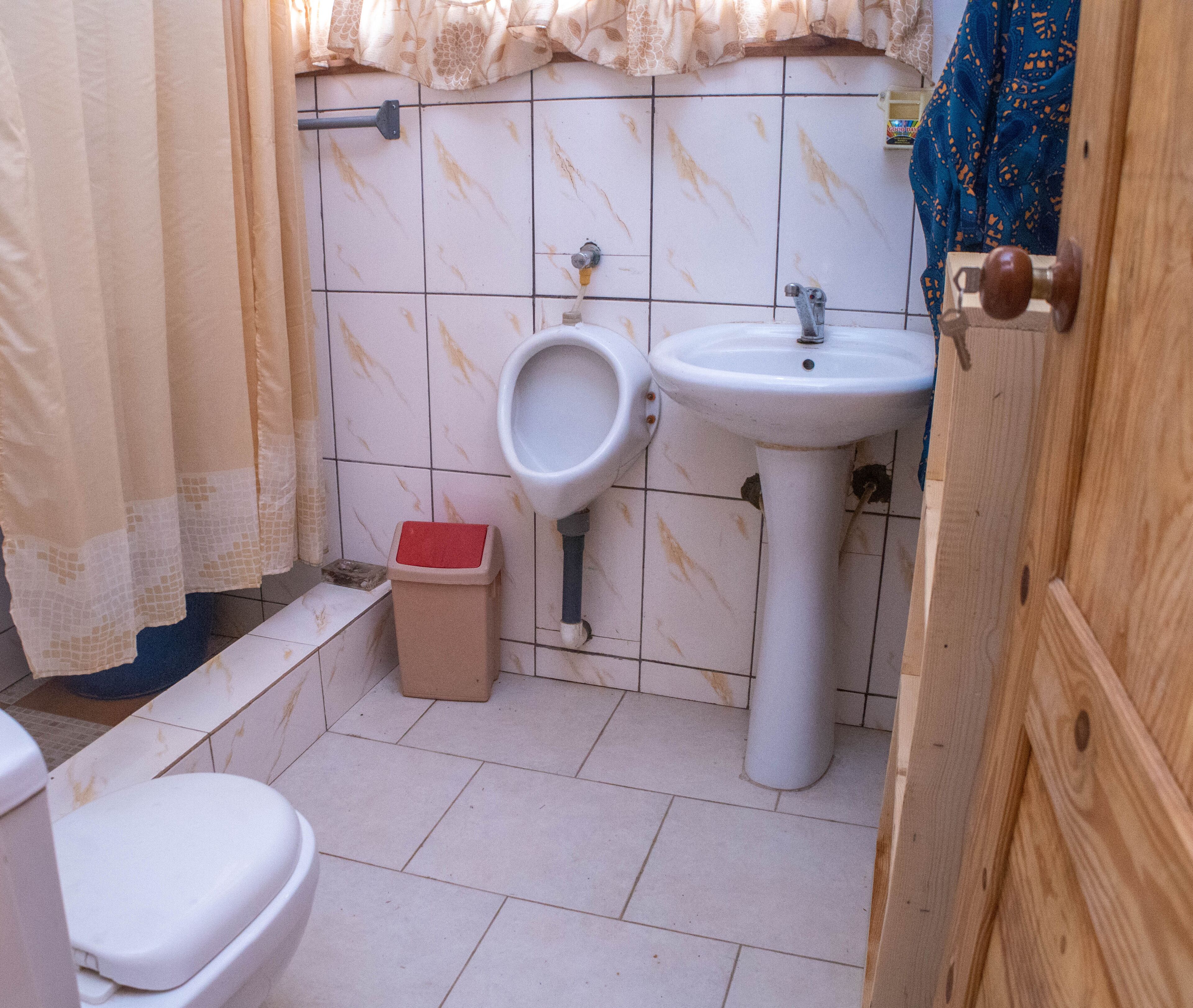 Uma casa de banho pequena com sanita, lavatório e chuveiro.