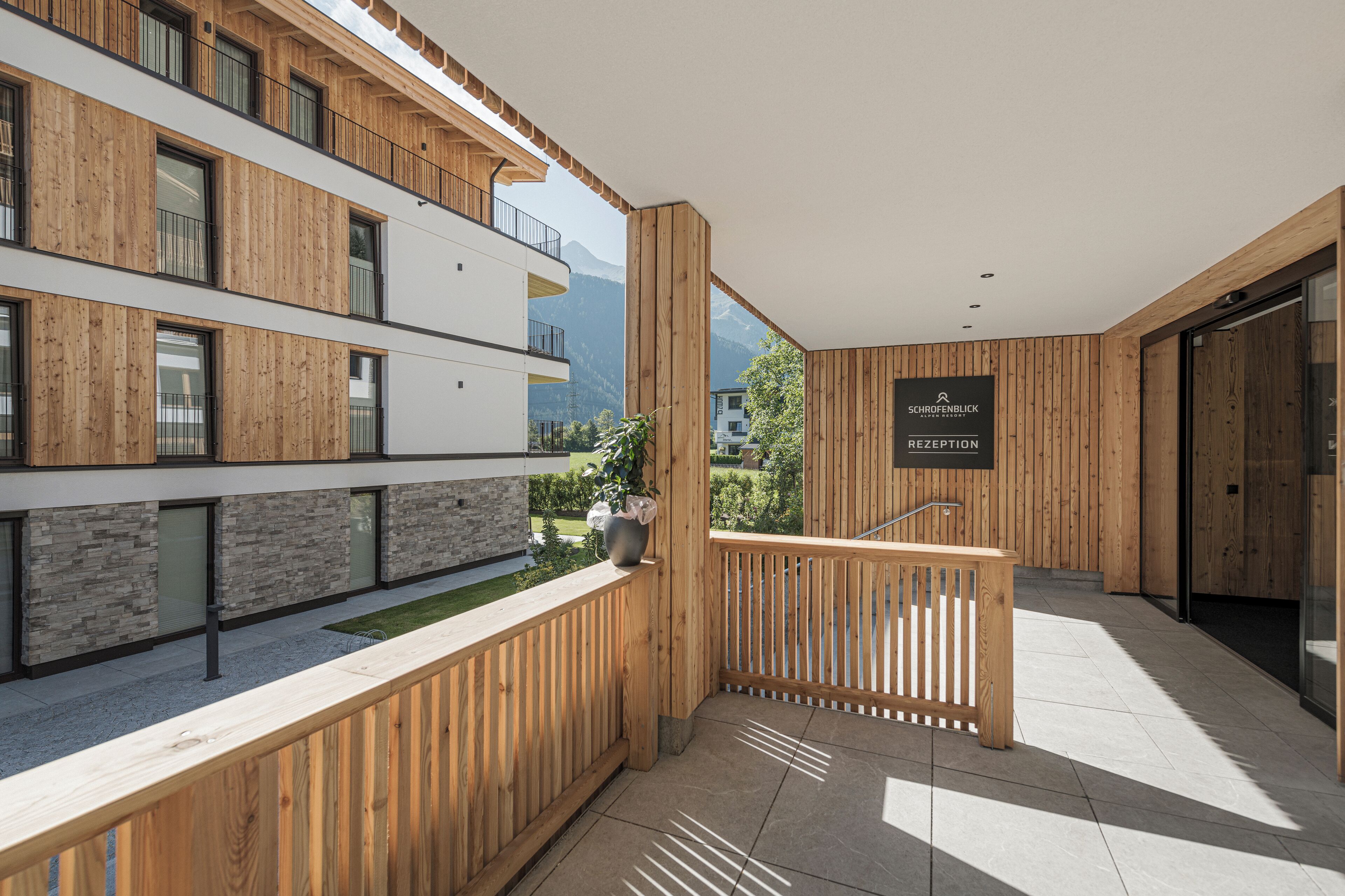 A modern building with wooden paneling, a reception area, and a view of mountains.